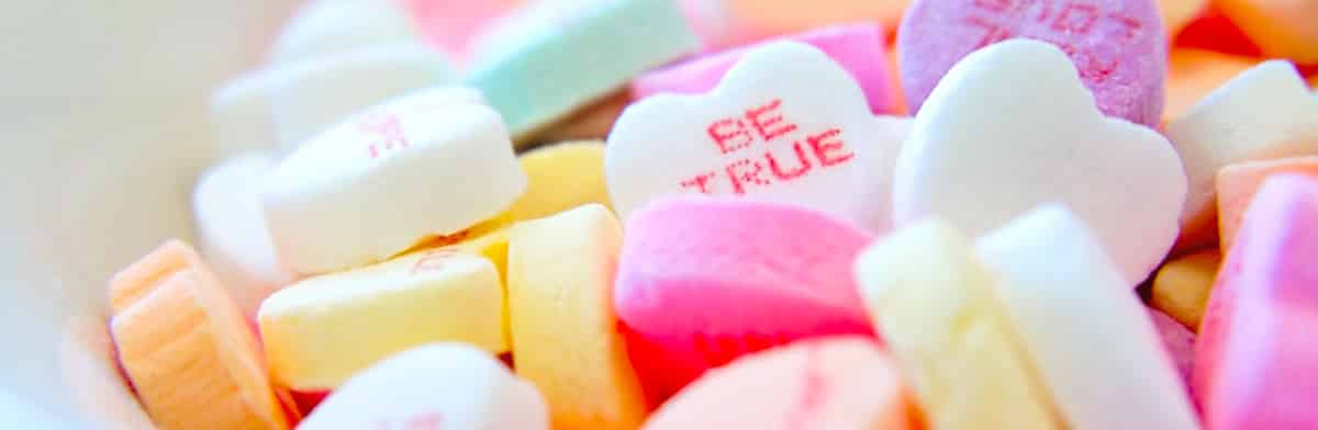 Pastel candy hearts, one printed with the words BE TRUE